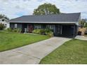 Gray house with a long driveway and lush green lawn at 1006 39Th W Ave, Bradenton, FL 34205