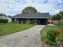 Dark gray house with a long driveway and landscaping at 1006 39Th W Ave, Bradenton, FL 34205