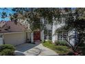 Two-story house with a red door and landscaping at 9330 Hampshire Park Dr, Tampa, FL 33647