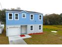 Two-story light blue house, white garage, and small yard at 3708 Wiggins Leaf St, Tampa, FL 33619