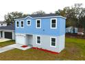 Two-story light blue house, white garage, and small yard at 3708 Wiggins Leaf St, Tampa, FL 33619