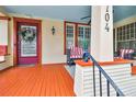 Inviting front porch with red painted floors and wicker furniture at 704 S Newport Ave, Tampa, FL 33606