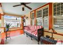 Bright and airy front porch with red painted floors and wicker furniture at 704 S Newport Ave, Tampa, FL 33606