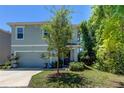 Two-story house with light blue exterior, two-car garage, and landscaping at 7516 Cypress Walk Dr, New Port Richey, FL 34655