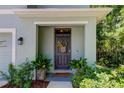 Inviting front door entrance with decorative basket and potted plants at 7516 Cypress Walk Dr, New Port Richey, FL 34655