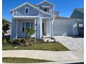 Two-story home with light blue siding, white garage door, and landscaping at 1574 Running Tide Pl, Sarasota, FL 34240