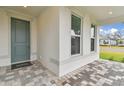 Charming front porch with a gray door and a brick-paved walkway at 9305 Barnacle Ln, Parrish, FL 34219