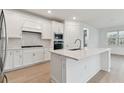 Modern kitchen with white cabinets, quartz countertops, and stainless steel appliances at 9305 Barnacle Ln, Parrish, FL 34219