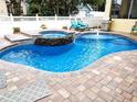 Backyard pool with brick pavers, a waterfall feature, and lounge chairs for relaxing at 3639 Hurston St, New Port Richey, FL 34655