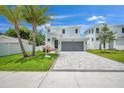 Two-story home with gray garage door and paver driveway at 2345 Bahia Vista St, Sarasota, FL 34239