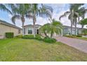 Tan house with palm trees and a brick driveway at 1817 Pacific Dunes Dr, Sun City Center, FL 33573