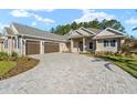 Two-story house with stone accents and a three-car garage at 5018 Elm Leaf Dr, Brooksville, FL 34601