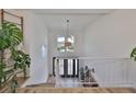 Bright entryway with a two-story ceiling, double doors, and hardwood floors; view from the upper level at 4334 Sanddollar Ct, New Port Richey, FL 34652