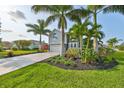 Two-story house with gray siding, stone accents, and a two-car garage; lush landscaping with palm trees at 4334 Sanddollar Ct, New Port Richey, FL 34652