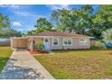 Tan house with carport, landscaped yard, and American flag at 6921 Onyx N Dr, St Petersburg, FL 33702
