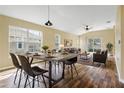 Bright dining room features a rustic table and chairs, hardwood floors, and access to the living area at 5723 Autumn Shire Dr, Zephyrhills, FL 33541