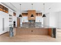 Luxurious kitchen boasts a central island with striking stone countertops and designer pendant lighting at 5006 W San Miguel St, Tampa, FL 33629