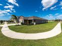One-story house with a two-car garage and a curved sidewalk at 11818 Tetrafin Dr, Riverview, FL 33579