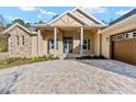 Front elevation showcasing a stone and shingle home at 5034 Elm Leaf Dr, Brooksville, FL 34601