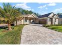 Two-story home with paver driveway and palm tree at 5034 Elm Leaf Dr, Brooksville, FL 34601