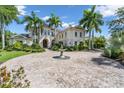 Elegant home with lush landscaping, paved circular driveway, and a stone fountain feature at 19451 Ganton Ave, Bradenton, FL 34202