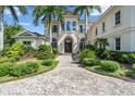Luxury home with arched windows, manicured landscaping, and a beautiful paved circular driveway at 19451 Ganton Ave, Bradenton, FL 34202