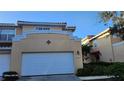 Two-story home featuring a large, white garage door and neutral-colored stucco exterior at 277 Valencia Cir, St Petersburg, FL 33716