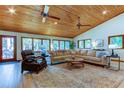 Spacious living room with vaulted wood ceilings, large windows, and comfortable seating at 17210 Orangewood Dr, Lutz, FL 33548