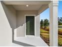 Modern front door entry with covered porch and columns at 10536 Hidden Banks Gln, Parrish, FL 34219