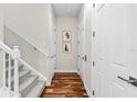 Hallway features hardwood floors and white trim, leading to carpeted stairs and multiple doors at 6030 Printery St # 105, Tampa, FL 33616