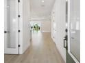 Bright hallway with white walls and luxury vinyl plank flooring leads to a light-filled living space at 683 Allora Ave, Nokomis, FL 34275
