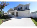 Two-story home with gray siding, white trim, and a large driveway at 3221 20Th N St, St Petersburg, FL 33713