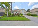 Two-story house with a three-car garage and beautifully landscaped front yard at 18050 Cozumel Isle Dr, Tampa, FL 33647