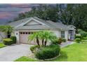 Front view of a house with a two-car garage and lush landscaping at 604 Masterpiece Dr # 604, Sun City Center, FL 33573