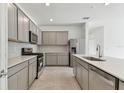Modern kitchen with gray cabinets, stainless steel appliances, and a large island at 1279 Kazaz Ct, Zephyrhills, FL 33540