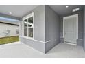 Gray front porch with a light gray door and a window at 1285 Kazaz Ct, Zephyrhills, FL 33540