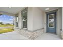 Front entry with blue door and stone accents at 37886 Clinch Cir, Zephyrhills, FL 33540