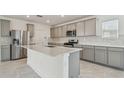 Modern kitchen with grey cabinets, quartz countertops, and stainless steel appliances at 1209 Kistna Dr, Zephyrhills, FL 33540