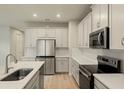Modern kitchen with stainless steel appliances and white cabinets at 3782 Maxwell Park Dr, Sun City Center, FL 33573