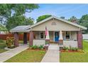 Quaint craftsman home with a carport and well-manicured lawn at 104 W Henry Ave, Tampa, FL 33604