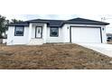 Newly constructed home with a white exterior, dark gray accents, and a two-car garage at 14018 Barlington St, Spring Hill, FL 34609