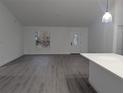 Bright and spacious living room with gray vinyl flooring and a view to the kitchen at 14018 Barlington St, Spring Hill, FL 34609