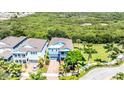 Two-story light blue house nestled in a community with lush greenery and a pond at 905 Seagrape Dr, Ruskin, FL 33570