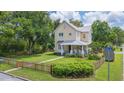 Charming two-story yellow home with a welcoming front porch and a neatly fenced yard at 14006 5Th St, Dade City, FL 33525