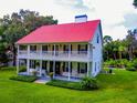Two-story house with red roof, wrap-around porch, and a pool in the backyard at 4502 Hill Dr, Valrico, FL 33596