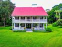 Two-story white house with red roof, large porch, and lush green lawn at 4502 Hill Dr, Valrico, FL 33596