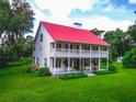 Two-story home, red metal roof, large porch, and spacious yard at 4502 Hill Dr, Valrico, FL 33596