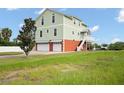 Green two-story house with two-car garage and a side yard at 8932 Rocky Creek Dr, Tampa, FL 33615