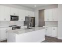 Modern kitchen with a center island, stainless steel appliances, and white cabinetry at 10288 Surrey Rose Dr, San Antonio, FL 33576