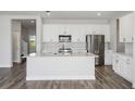 Bright kitchen featuring white cabinets, stainless steel appliances, and a large island at 10288 Surrey Rose Dr, San Antonio, FL 33576